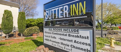 Une pancarte pour le Sitter Inn mettant en avant les services proposés, tels qu’un copieux petit-déjeuner continental, les appels locaux illimités, les chaînes de films HBO en version premium et l’hébergement gratuit pour les enfants.