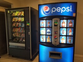 Máquina expendedora con la marca Pepsi y una variedad de aperitivos y bebidas.