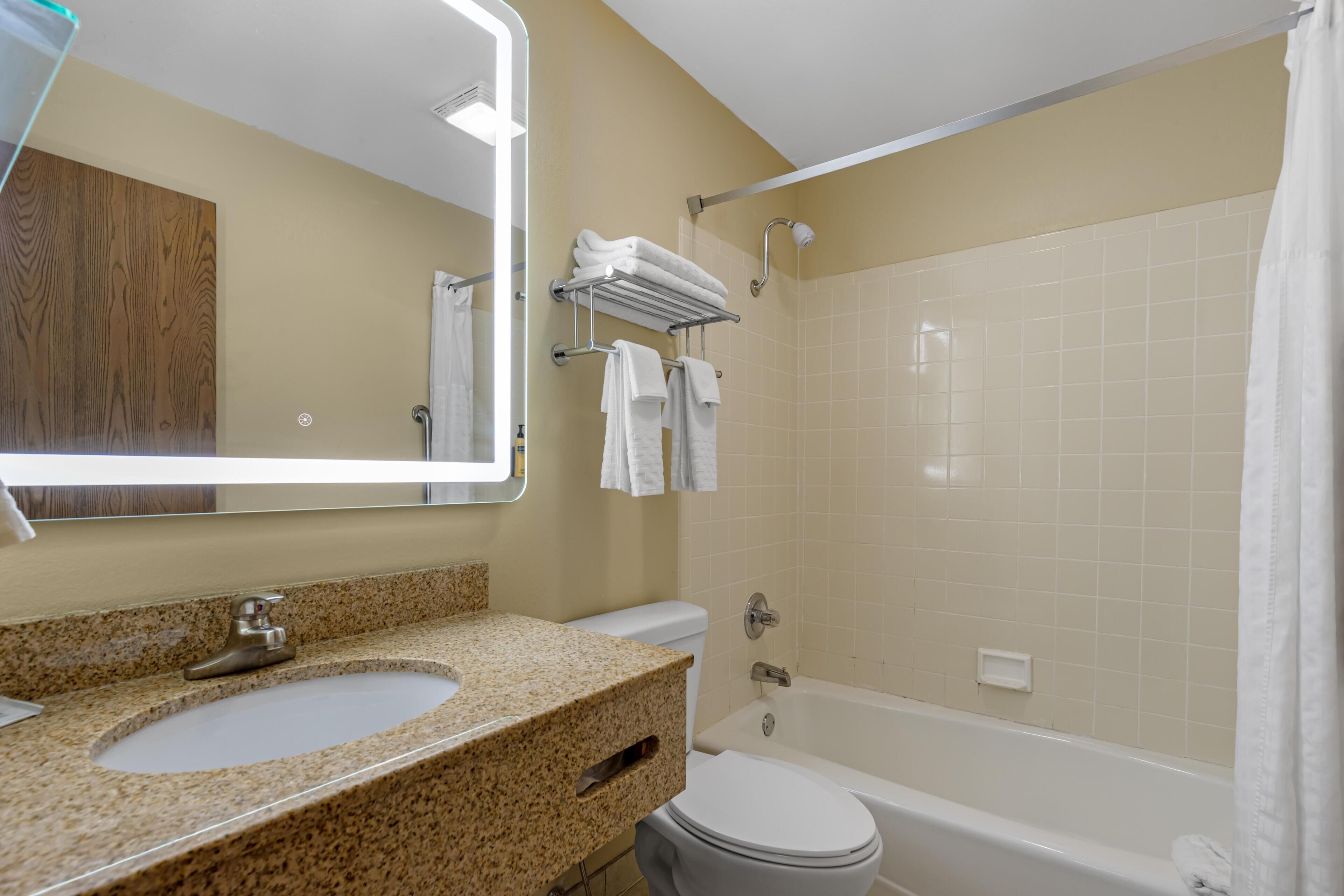 A bathroom with a sink, toilet, and bathtub.
