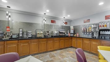 Una cocina moderna con estación de café, dispensador de leche y enfriador de bebidas.
