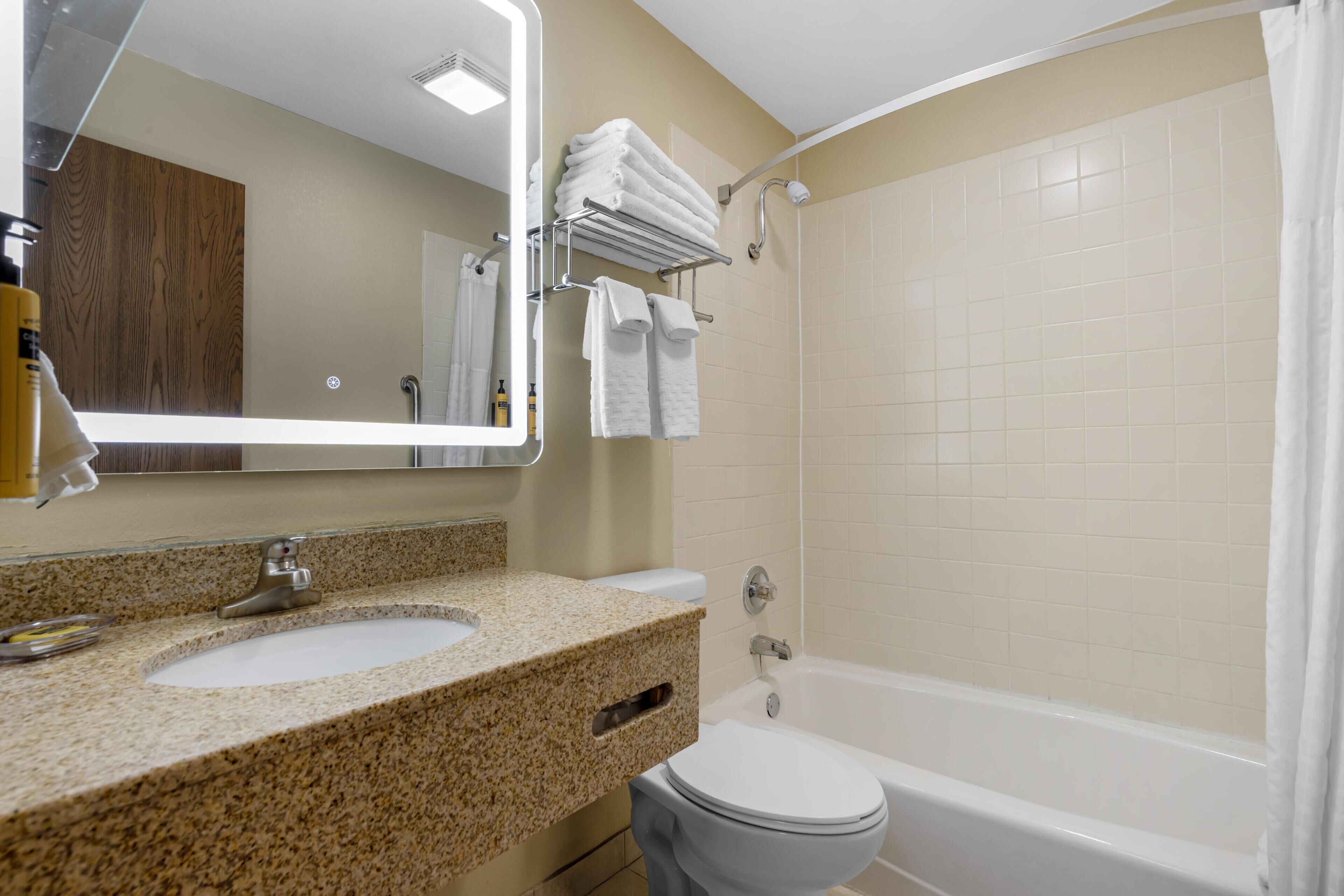 A bathroom with a sink, toilet, and bathtub.