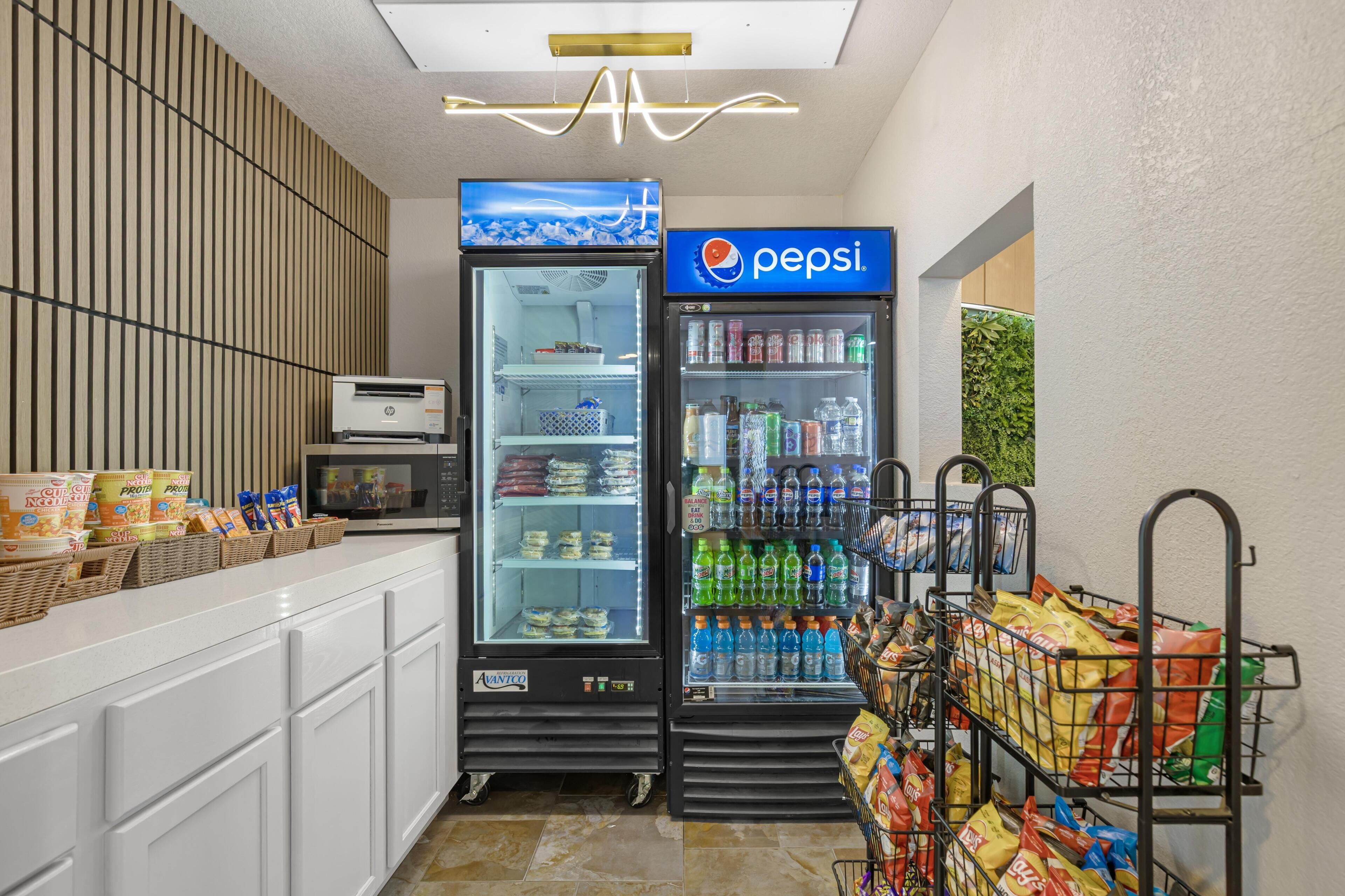 A vending machine area with a Pepsi refrigerator, a microwave, and snack dispensers.