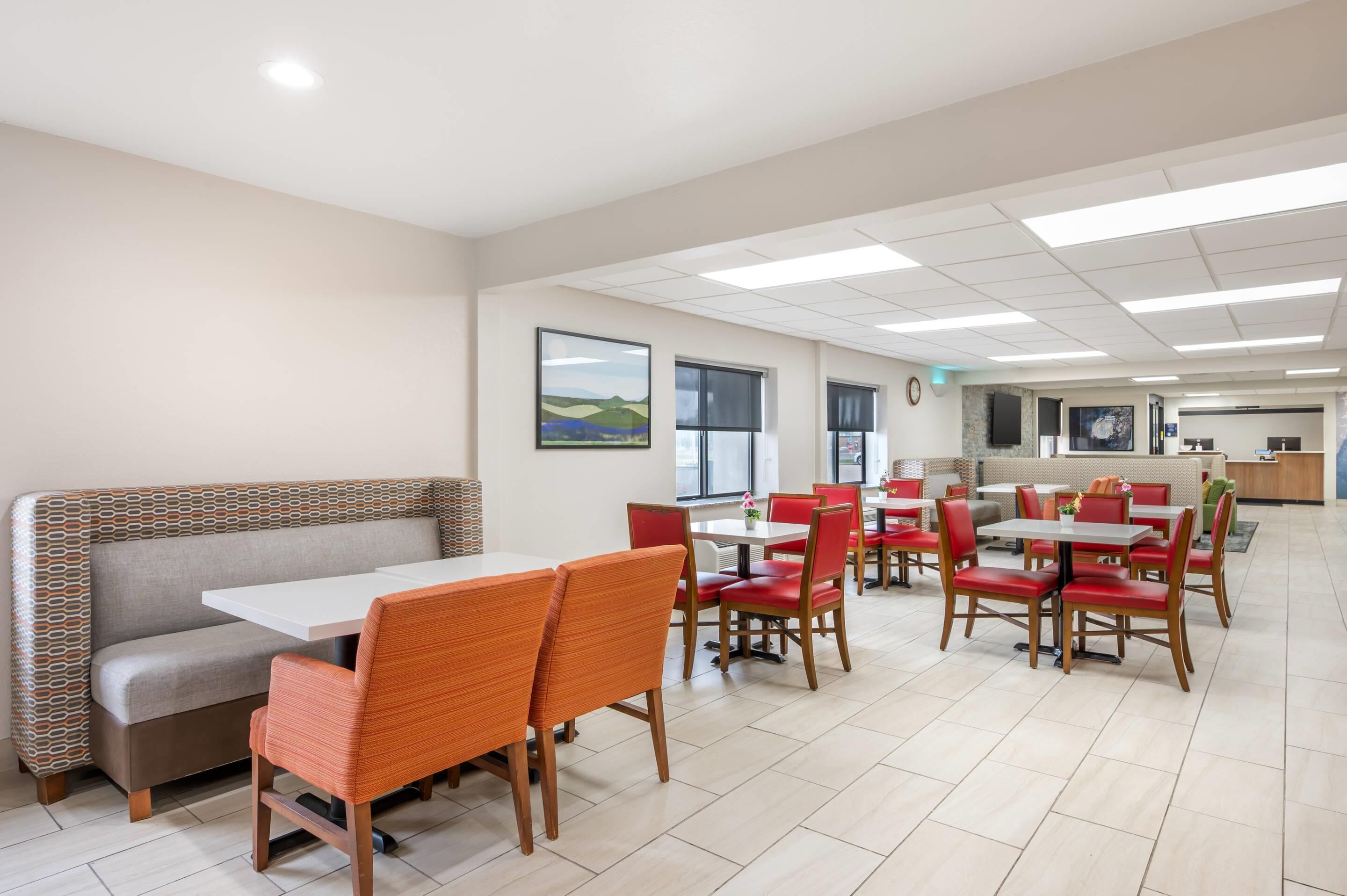 A modern dining area with booths and tables, a counter, and artwork on the walls.