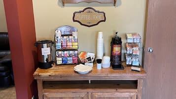 En kaffestation med en kaffebryggare, koppar och en skylt med texten ”Kaffehörnan”.
