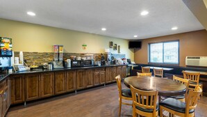 Una cocina con muebles de madera, una isla central con asientos y diversos electrodomésticos.