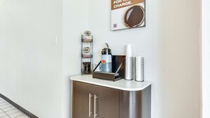 Un espace dédié au café, équipé d’une machine à café, de tasses et d’un panneau indiquant : « VOTRE DOSE DE CAFÉ MATINALE, OFFERTE ».