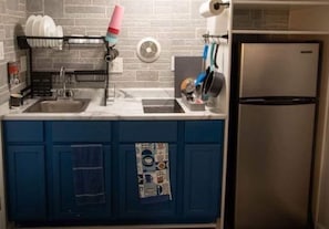 Efficient kitchen with a sink, refrigerator, and dish rack.