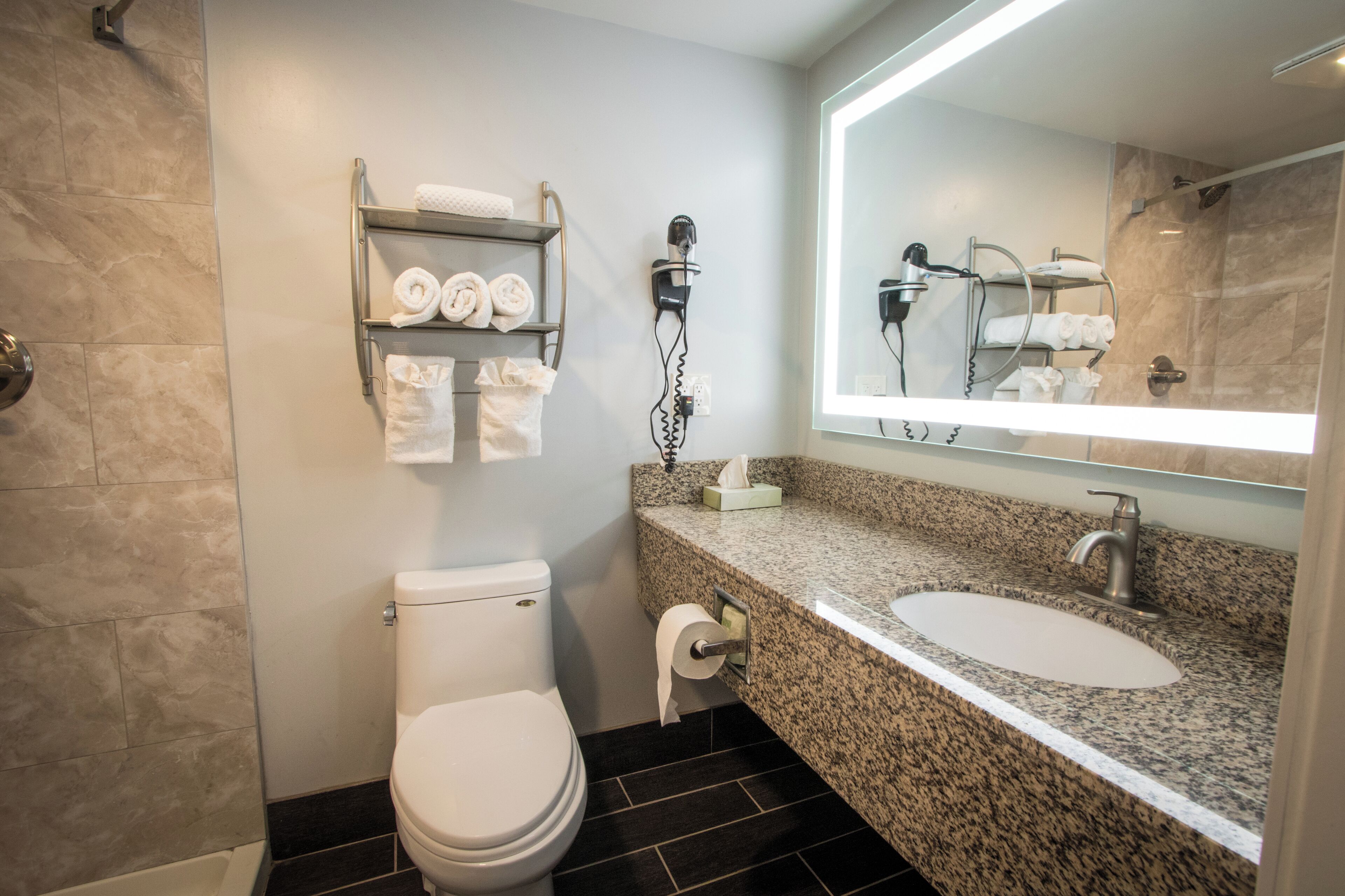 A bathroom with a toilet, sink, and towel rack.