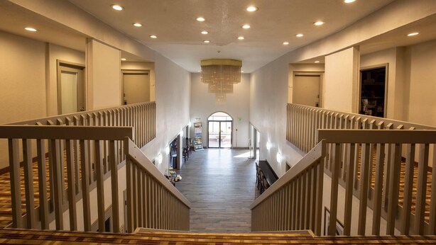 A spacious interior with a central staircase, multiple doors, and a chandelier. - Quality Inn & Suites Portage Central (Portage)