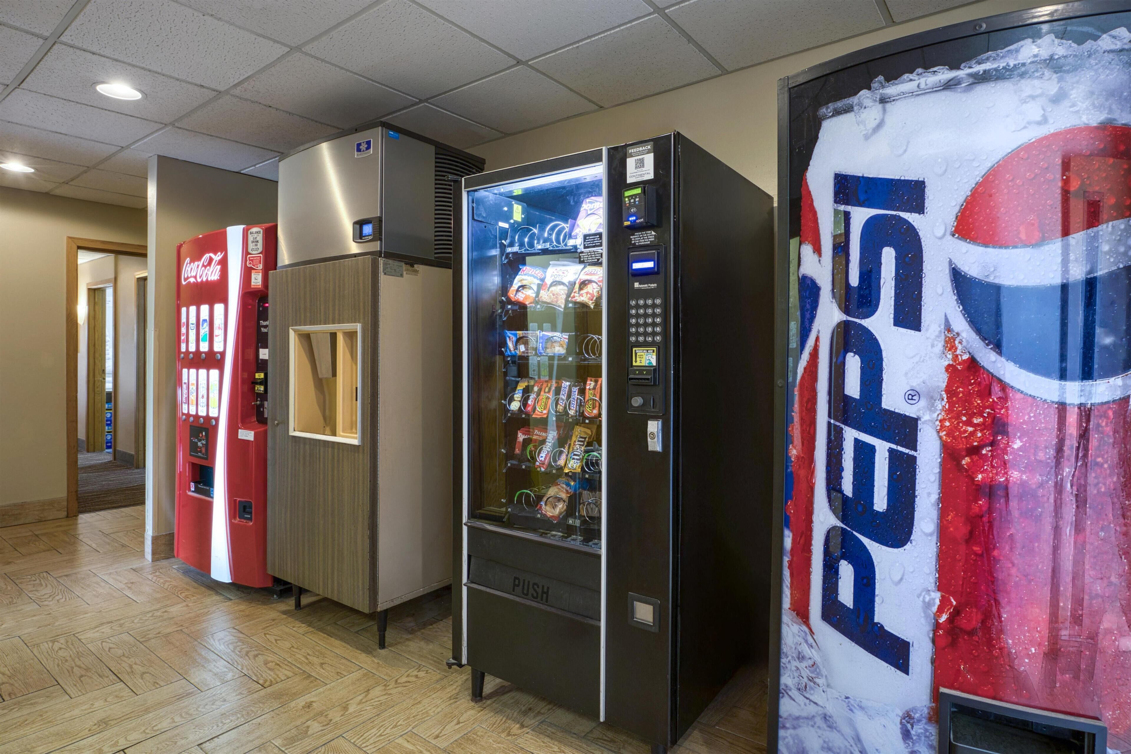 A row of vending machines, including Coca-Cola and Pepsi, in a hallway.