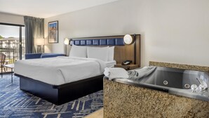 Una habitación de hotel con una cama, un baño con bañera, un escritorio y una silla.
