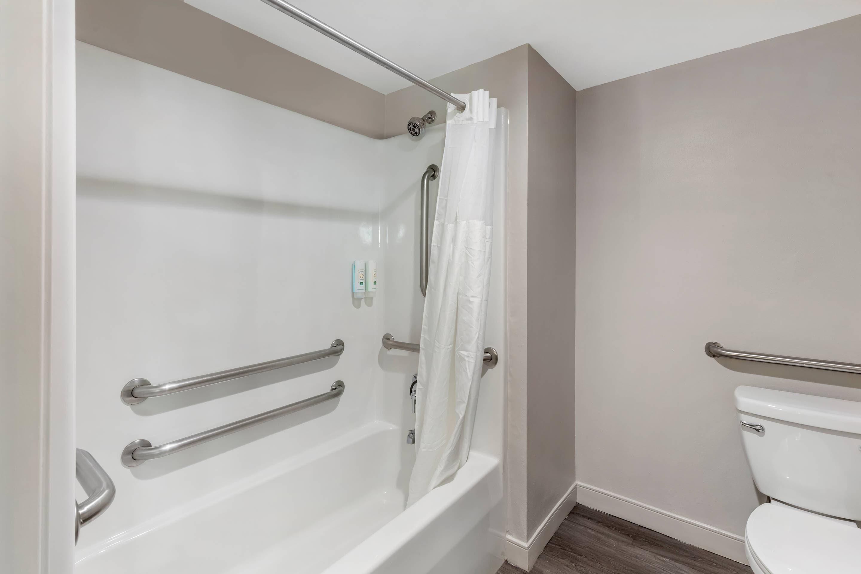 Een badkamer met een bad, toilet en douchegordijn.