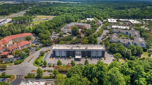 An aerial view of a hotel complex with multiple buildings, parking areas, and surrounding greenery.