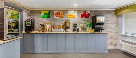 A modern kitchen area with a built-in coffee station, a refrigerator, and a microwave.