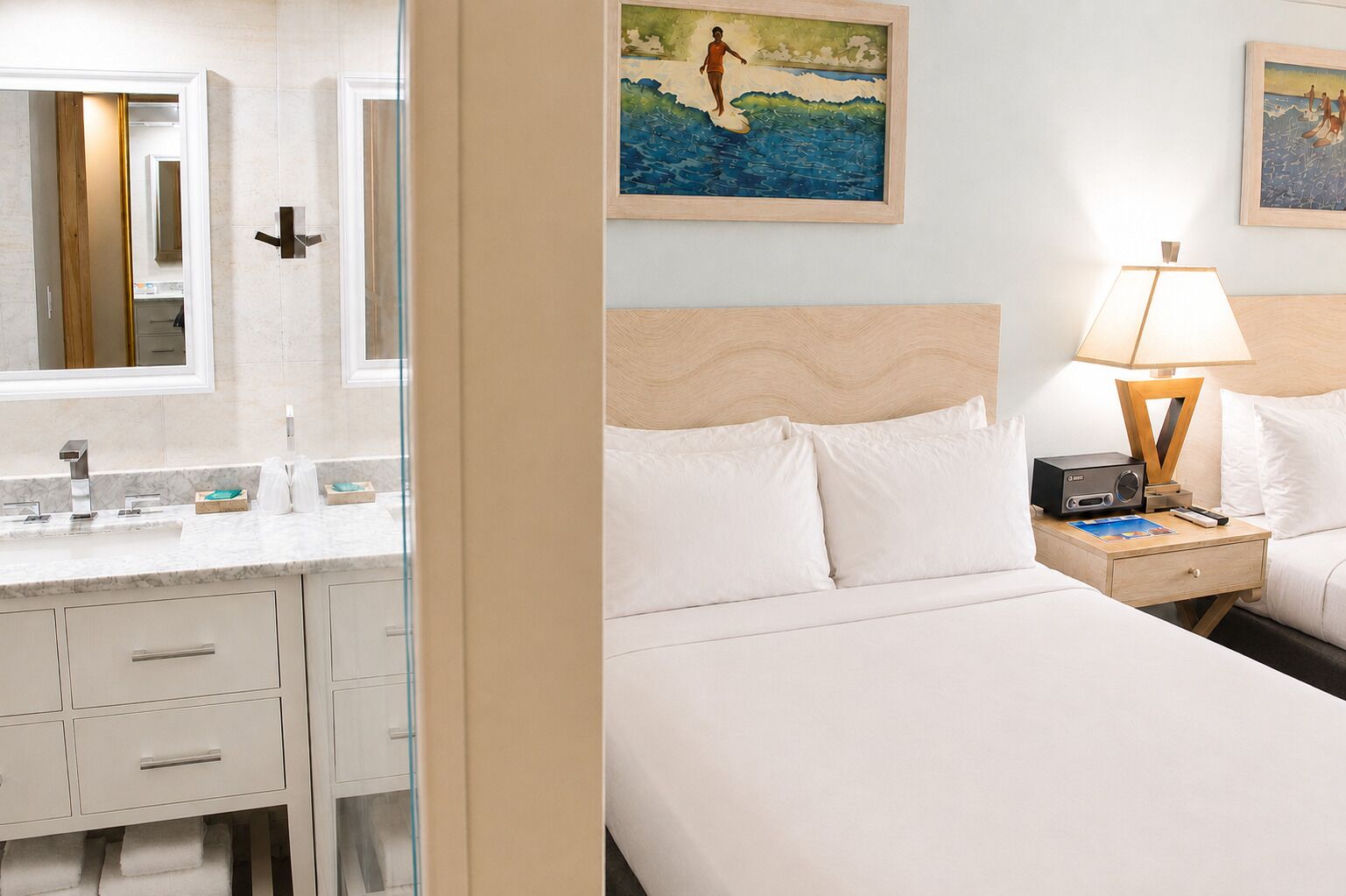 Et hotelværelse med seng, natbord, lampe og et billede på væggen.
