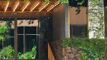 A hotel entrance with a sign reading 'HOTEL LA CLOIX,' a wooden staircase, and a stone wall.