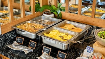 Un buffet proposant diffĂ©rents plats, chacun clairement identifiĂ©, notamment du riz frit, des Ćufs brouillĂ©s et des crĂȘpes.