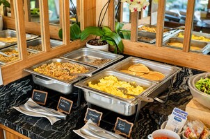 A buffet with labeled food sections including fried rice, scrambled eggs, and pancakes.