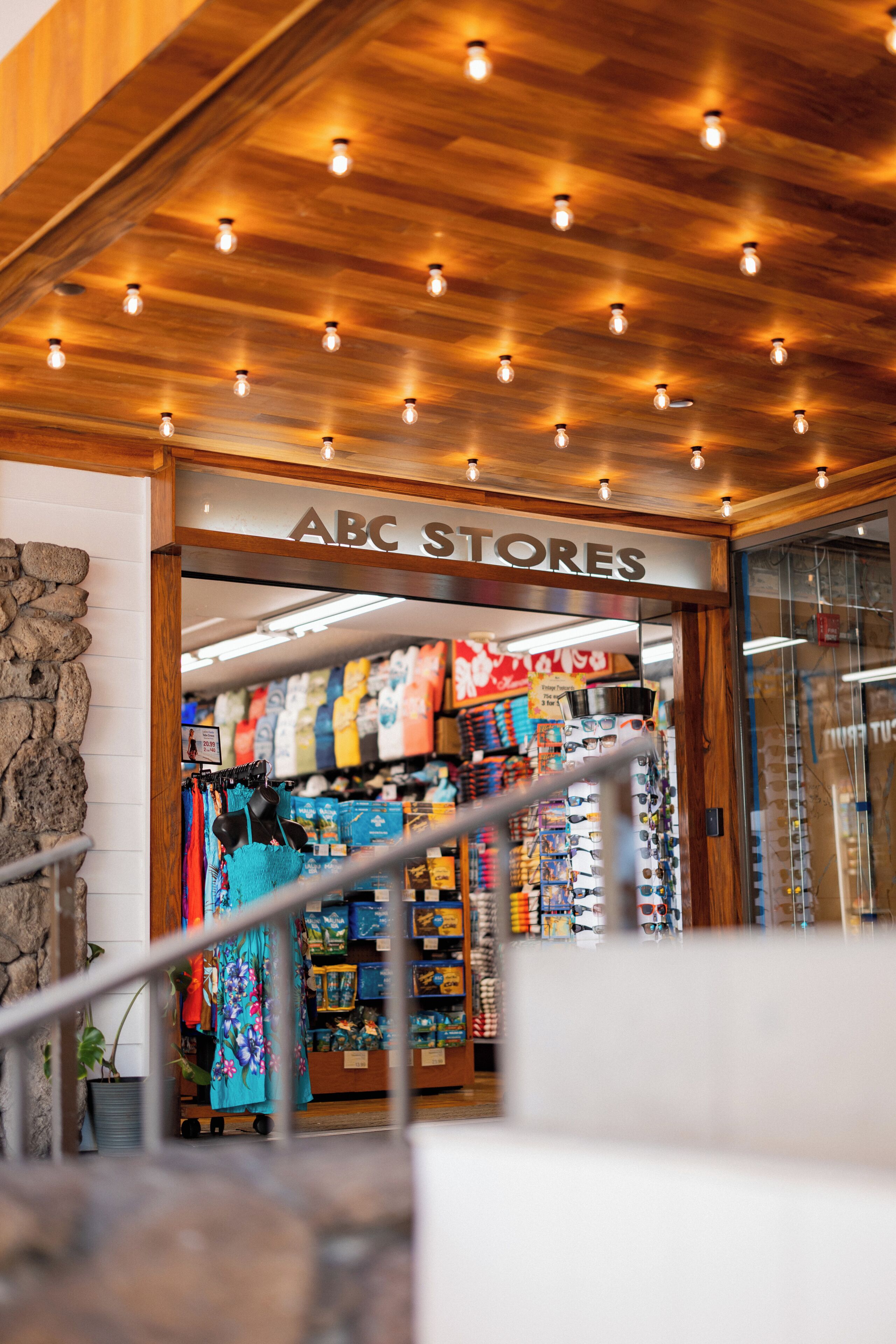 Entrada de una tienda con techo de madera y un letrero que dice 'ABC STORES'.