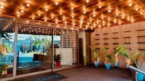 A modern interior with a wooden ceiling, glass doors, and potted plants. - Hotel La Croix (Honolulu)