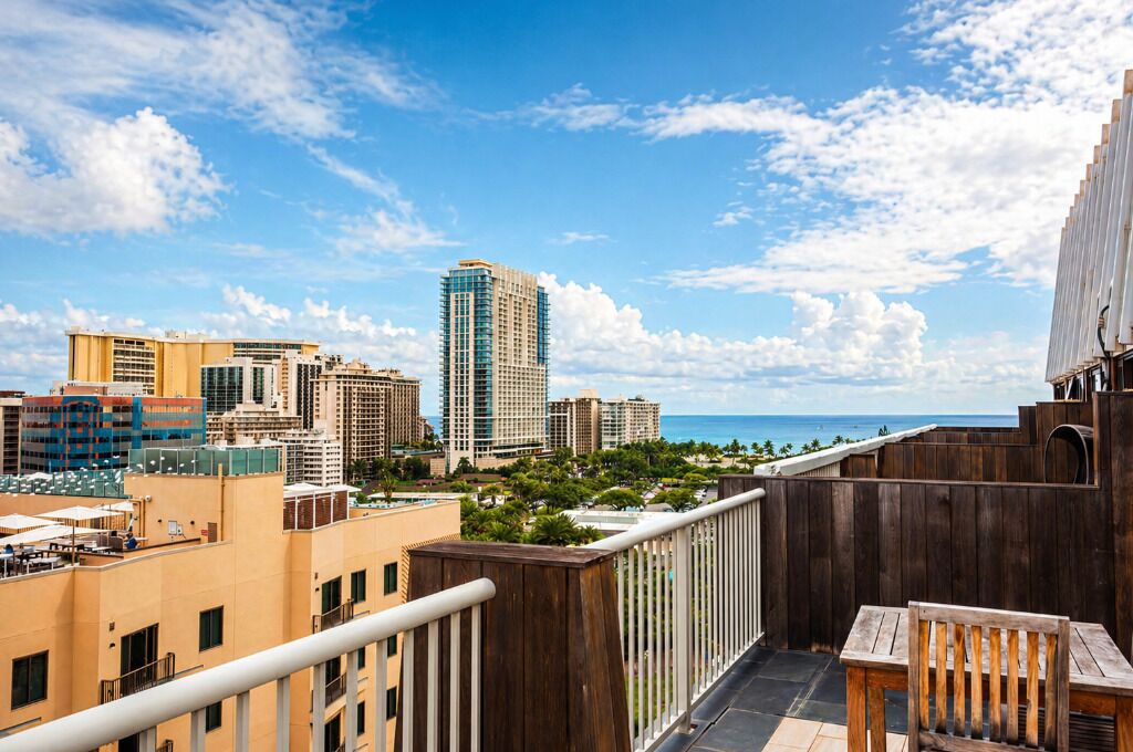 A high-rise building with a view of the ocean and other buildings.