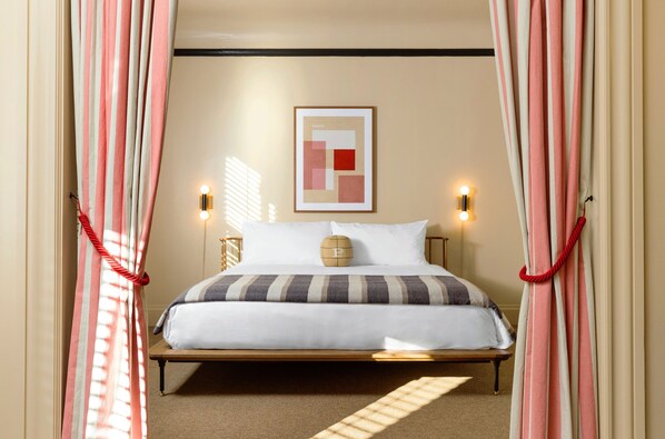 Cozy retreat with a neatly made bed, striped bedspread, and two pillows, set against a warm backdrop.