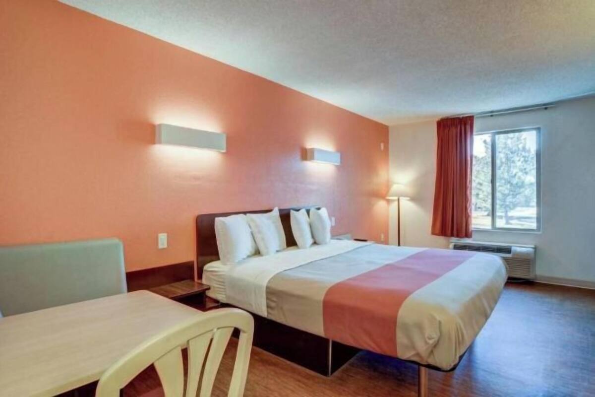 Ein Hotelzimmer mit Bett, Tisch und Stuhl.