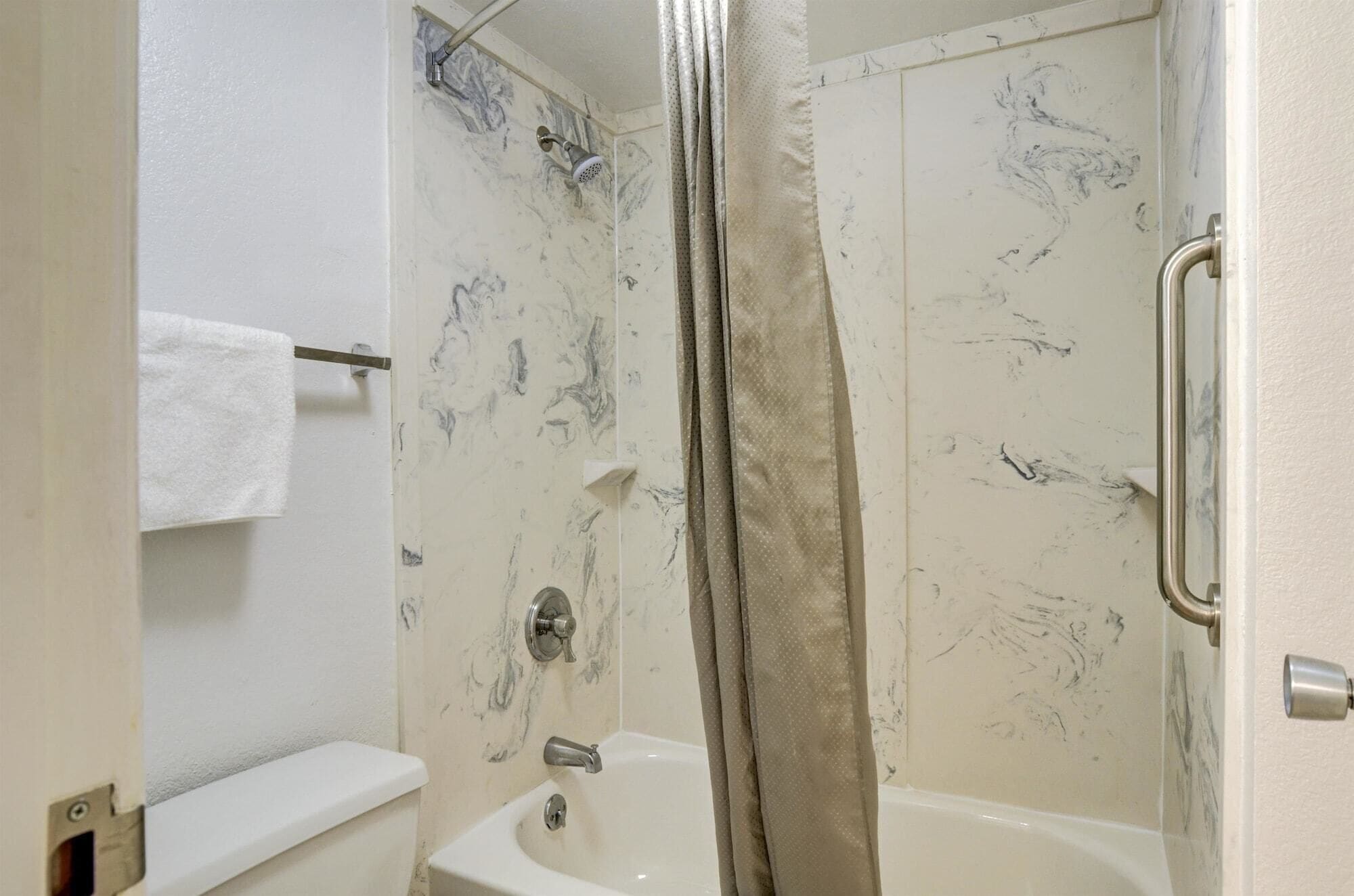 Une salle de bain avec une douche, des toilettes et une baignoire.