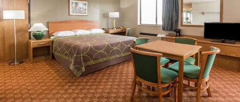 Een hotelkamer met een bed, een bureau, een stoel, een televisie en een raam met gordijnen.