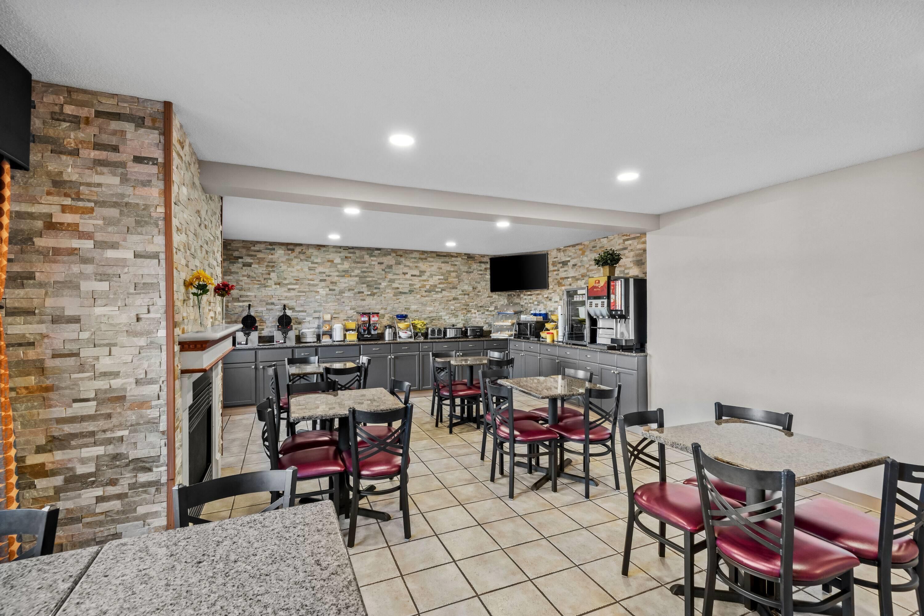 A modern kitchen with granite countertops, a built-in oven, and a flat-screen TV.