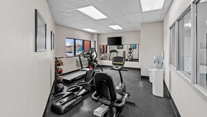 A gym with treadmills, elliptical machines, and a water dispenser. - Days Inn & Suites by Wyndham Des Moines Airport (Des Moines)
