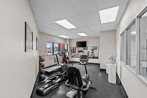 A gym with treadmills, elliptical machines, and a water dispenser. - Days Inn & Suites by Wyndham Des Moines Airport (Des Moines)