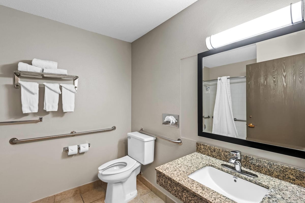Une salle de bain moderne équipée de toilettes, d’un lavabo et d’un porte-serviettes.