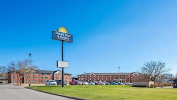 Señalización de Days Inn & Suites, un estacionamiento y un edificio con varios pisos y ventanas.