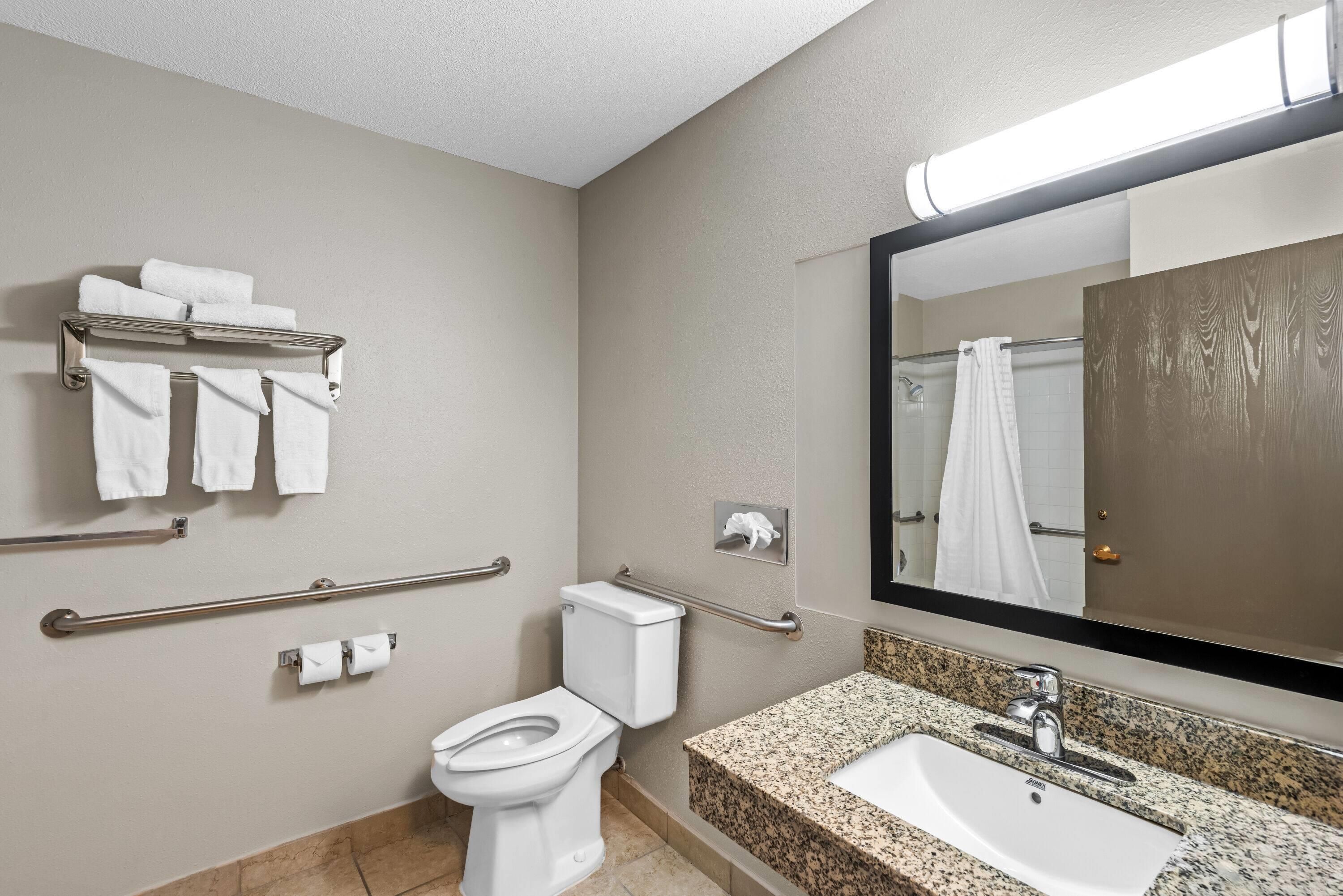 A modern bathroom with a toilet, sink, and towel rack.