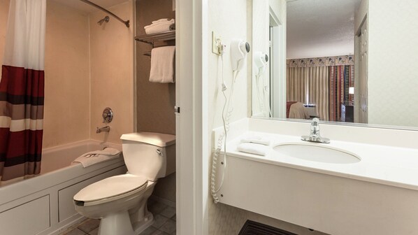 A bathroom with a shower, toilet, and sink.