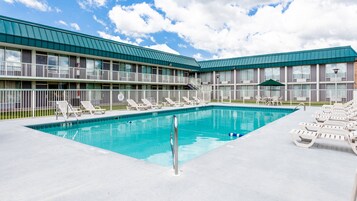 Una piscina al aire libre de temporada, sillones reclinables de piscina
