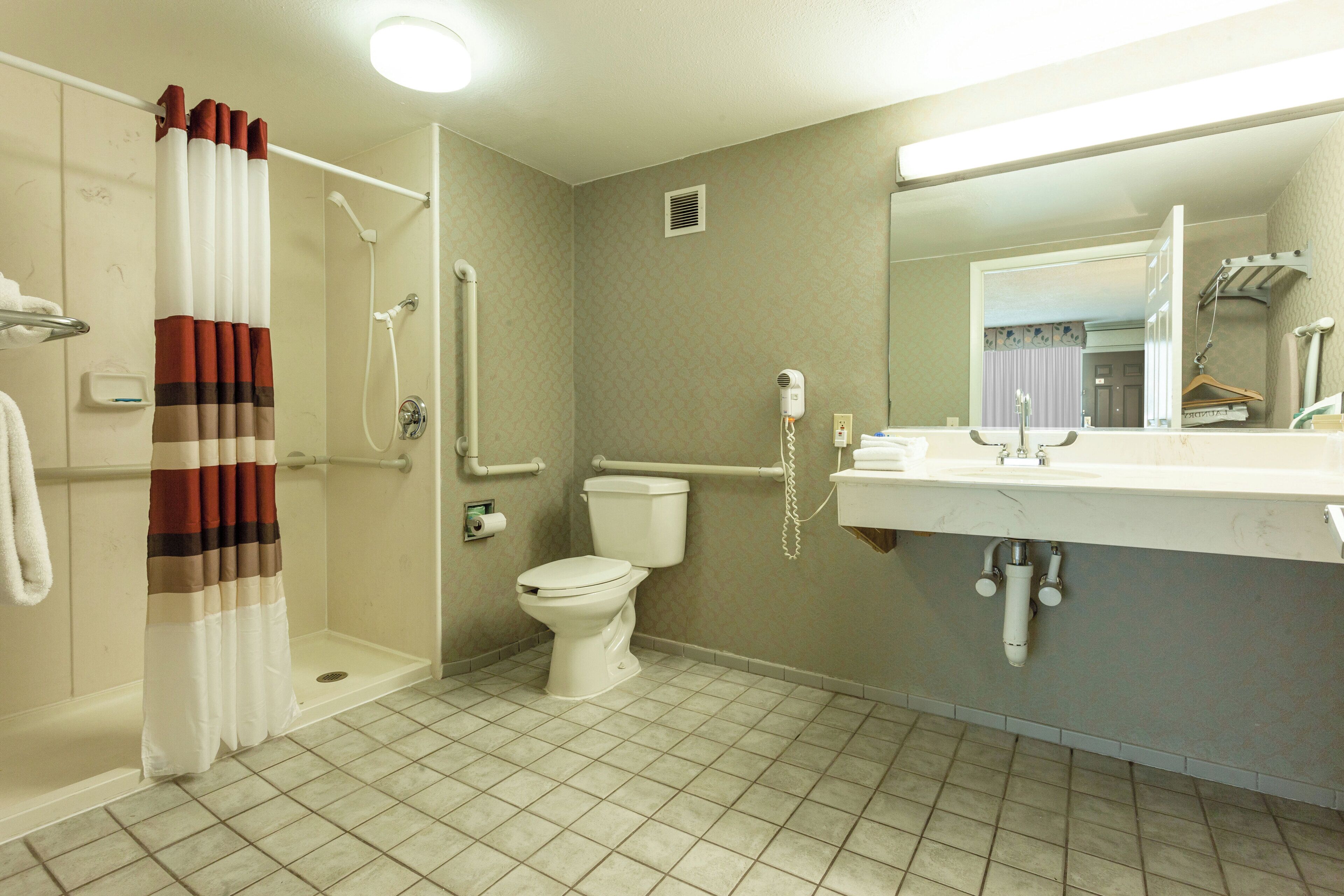 A bathroom with a shower, toilet, and sink.