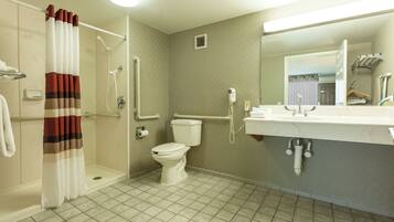 A bathroom with a shower, toilet, and sink.