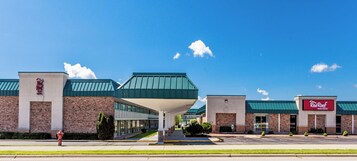 Un Red Roof Inn con un diseño arquitectónico moderno, que presenta un techo plano y fachada de ladrillo.