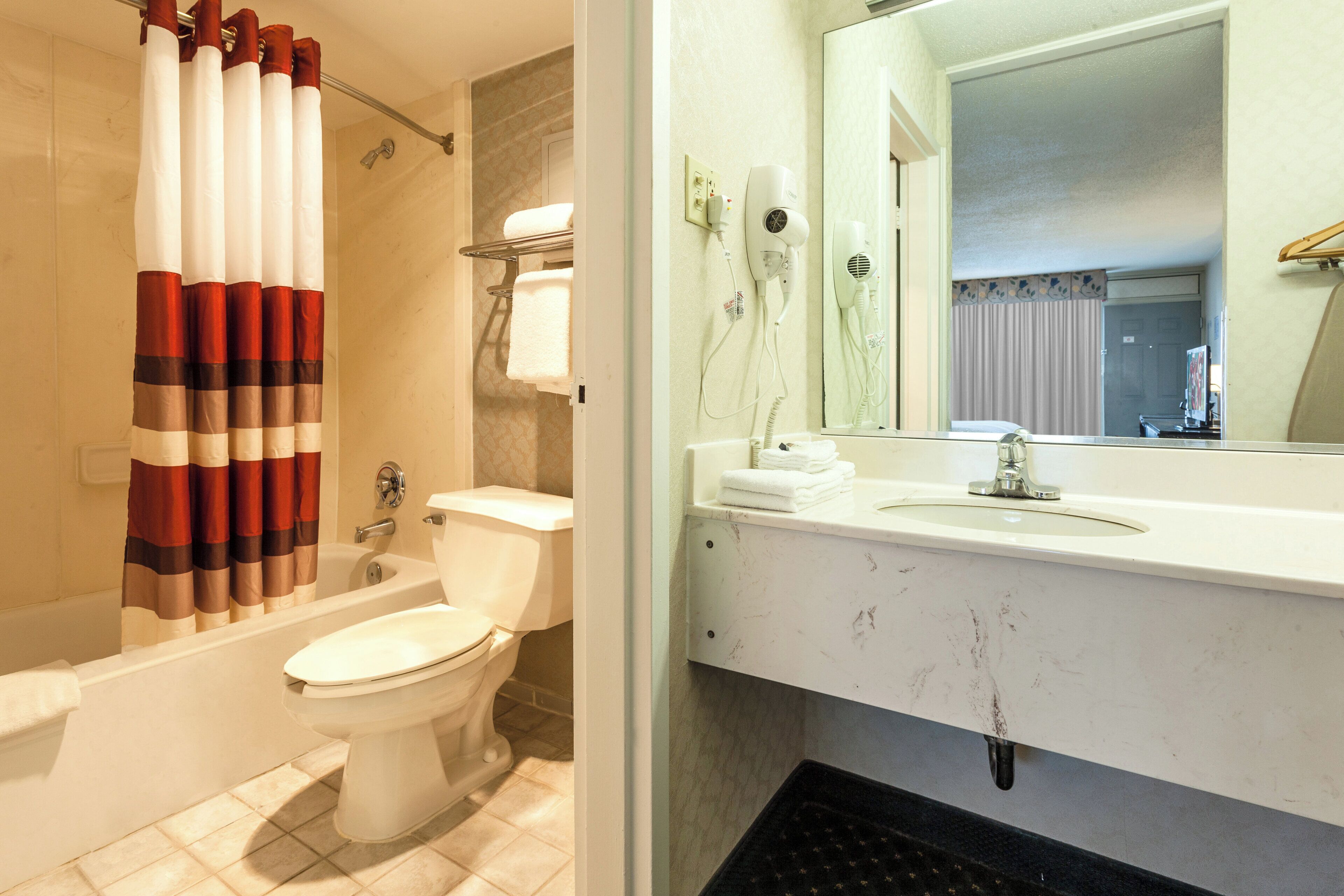 Une salle de bain avec une baignoire, des toilettes et un lavabo avec un miroir.