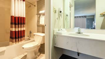 Une salle de bain avec une baignoire, des toilettes et un lavabo avec un miroir.