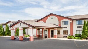 A hotel with a covered entrance, multiple windows, and a parking lot. - Super 8 by Wyndham Plymouth (Plymouth)