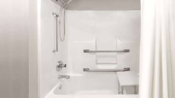Een moderne badkamer met een inloopdouche, handgrepen en een klein bankje.