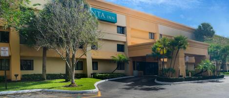 Un hotel con un letrero que dice "ANTA INN" y un estacionamiento con espacios delimitados.