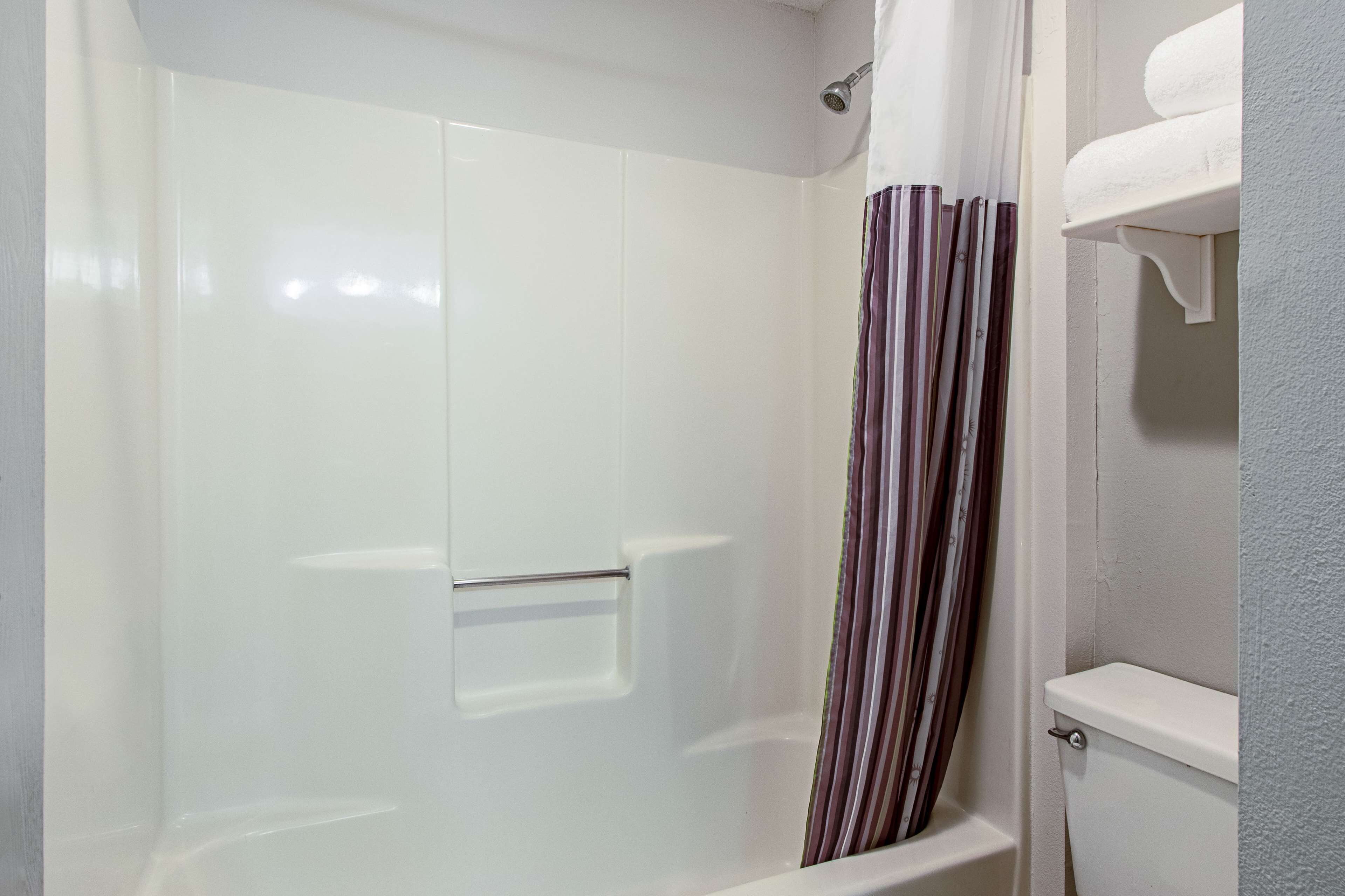 Ein Badezimmer mit Dusche, Toilette und Handtuchhalter.