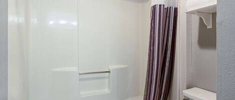 A bathroom with a shower, toilet, and towel rack.