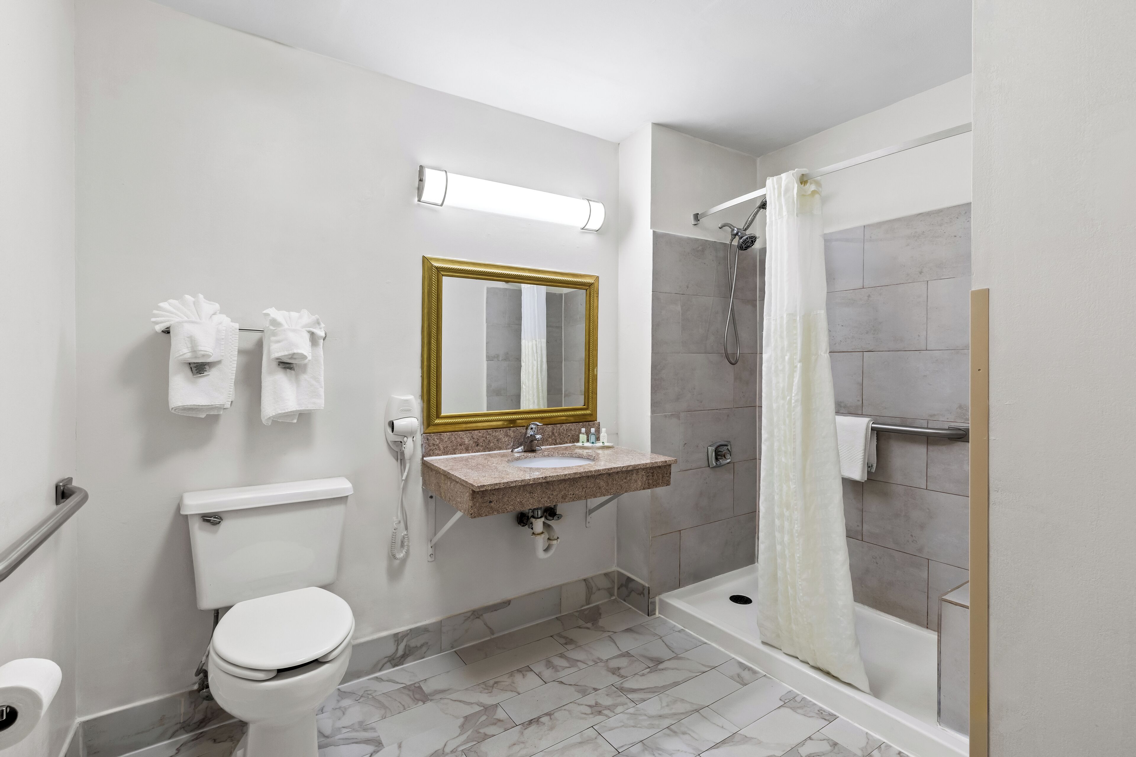 A modern bathroom with a toilet, sink, and shower.