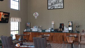 A breakfast bar with chairs, a clock, and a sign for a breakfast buffet.