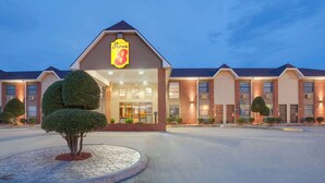 A hotel with a prominent 'Super 8' sign, brick facade, and symmetrical windows.